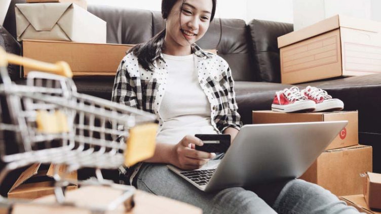 Woman holding her debit card and shopping online 