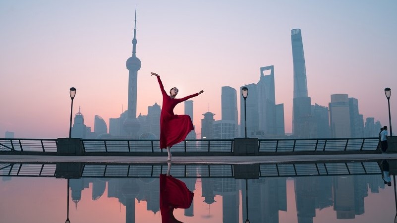 Women in red dress doing ballet on building roof 