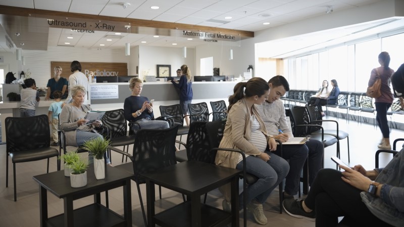 A pregnant woman sitting with a man and discussing about healthcare