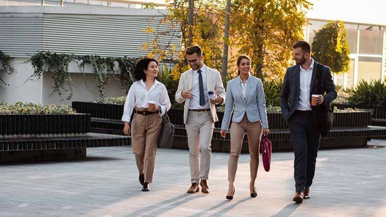 professionals walking on street with sit out area in the background