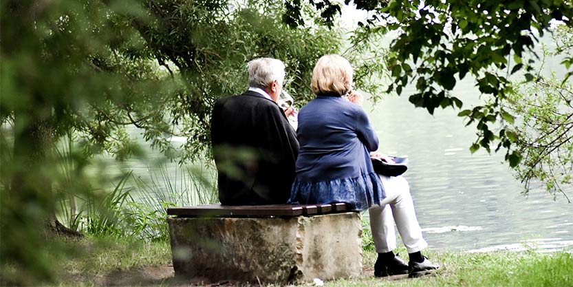 Two elderly people sitting on a bench