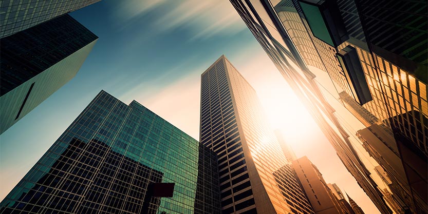 Sun shine behind large buildings