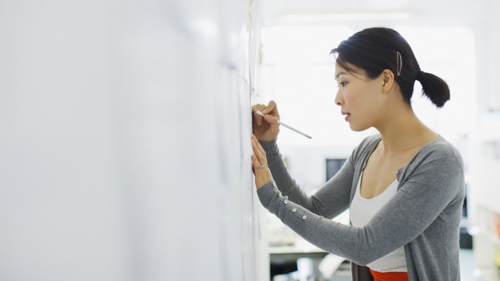 Women writting on paper sticked on the wall