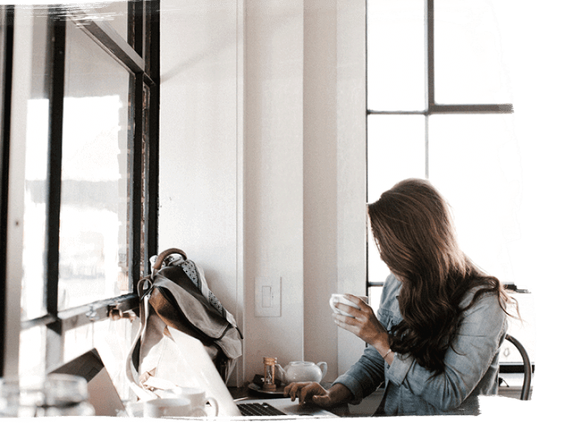 Lady working on Laptop with cup of coffee