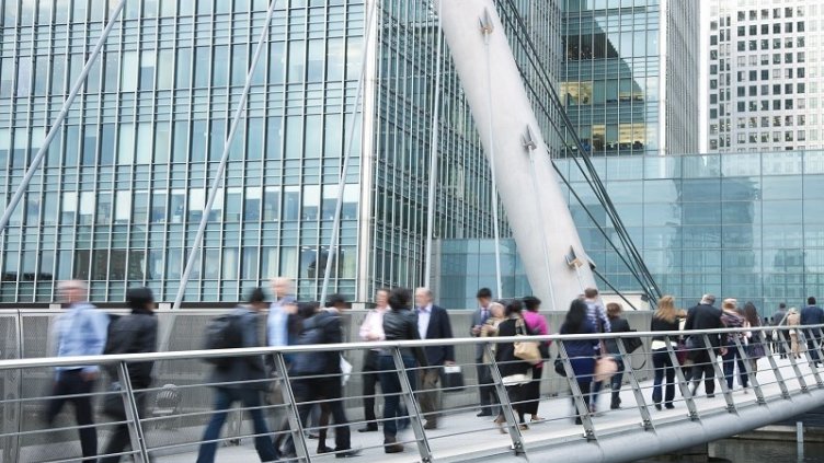 People crossing the bridge while going office 