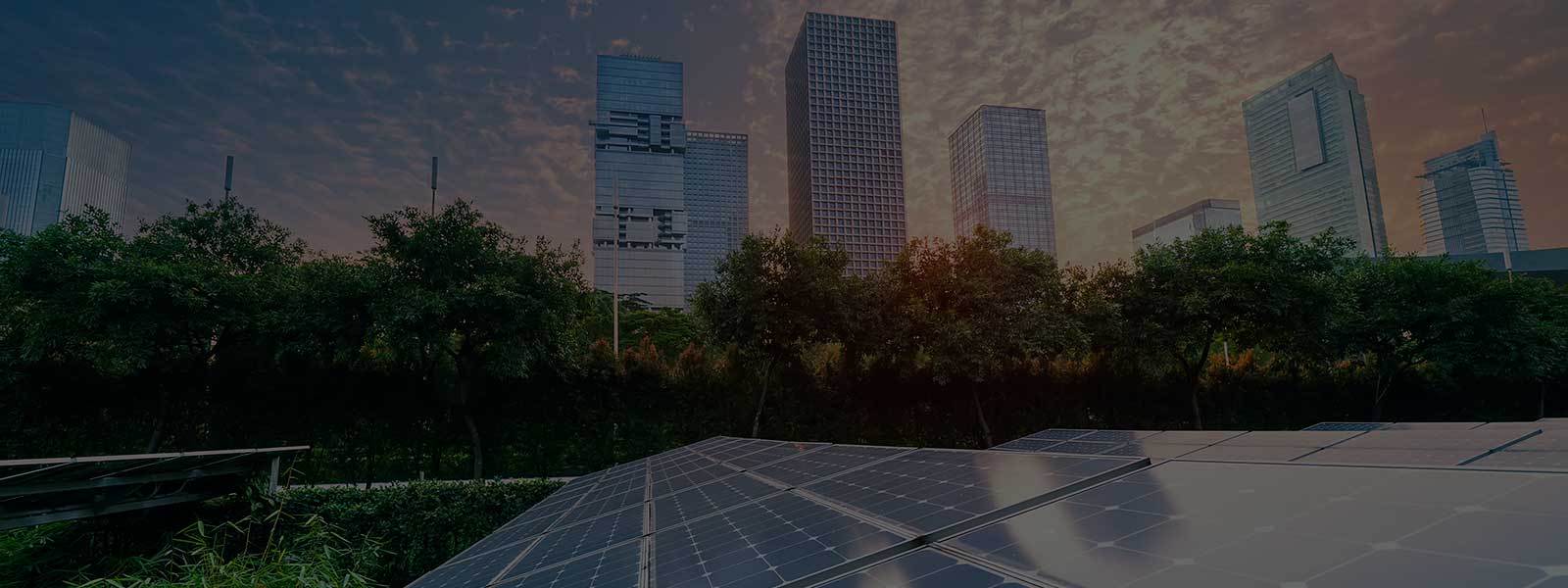 Solar panels and commercial buildings with a sunset backdrop