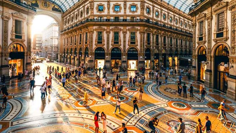 People in a luxury shopping mall in Milan at sunset.