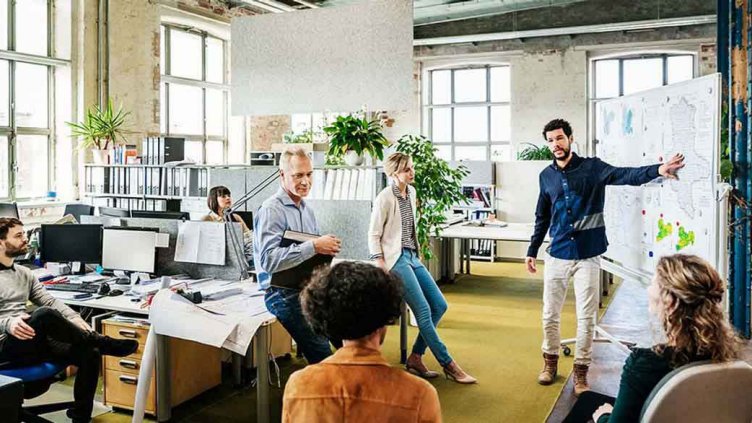 Office manager addressing his team in office workspace