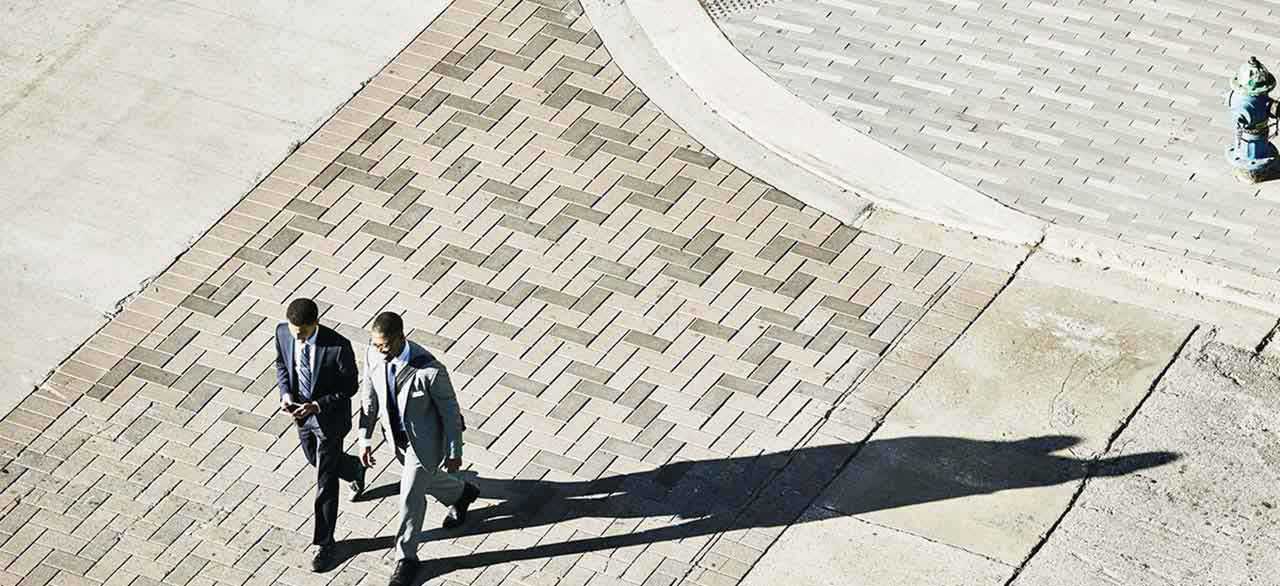 Overhead view of two investors walking while discussing