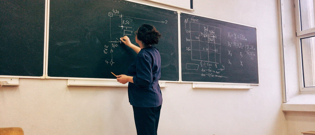 teacher writing on chalkboard